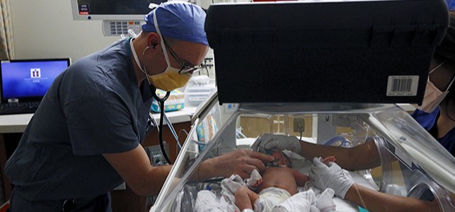 Dr. Casella listens to the heart of his tiny patient