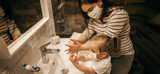 Mom and child wearing masks and washing hands
