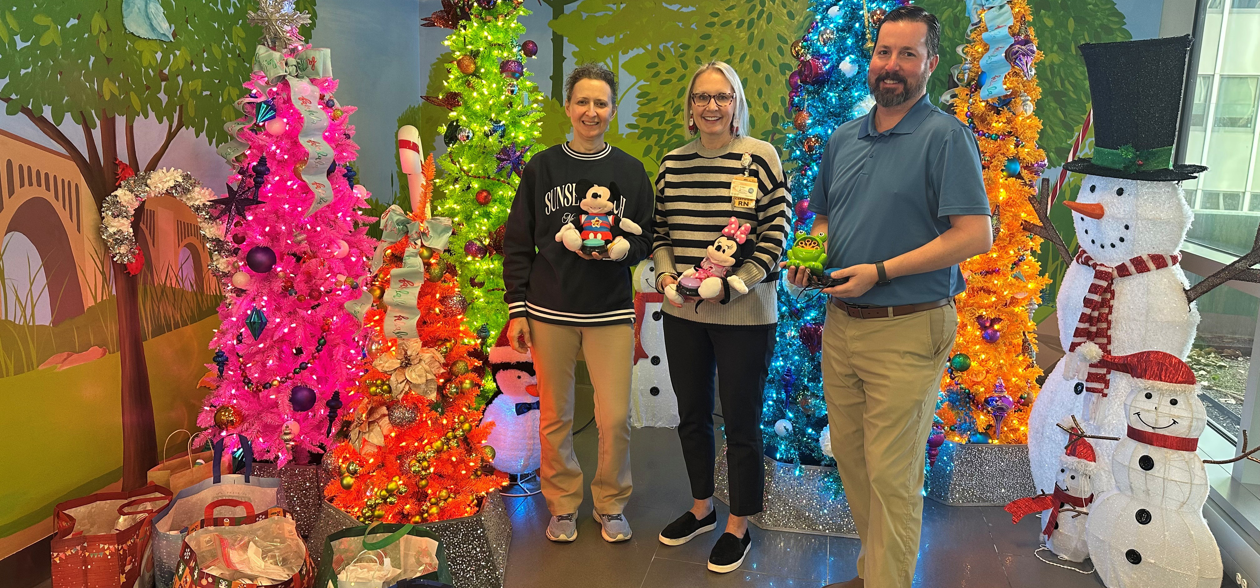 CHoR director of nursing Bridget Hutchinson accepts a toy donation from Dr. Michael Cabral and Monika Thrower