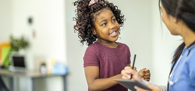 Young girl talking to nurse in doctor's office