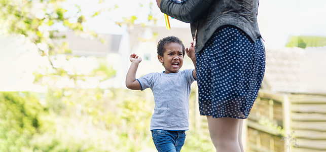 Young child crying and getting ready to hit adult