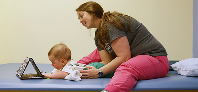 CHoR therapist works with a baby during tummy time