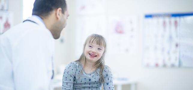 Pediatrician and girl patient smiling at each other