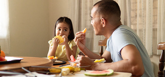 Father and daughter having breakfast at home