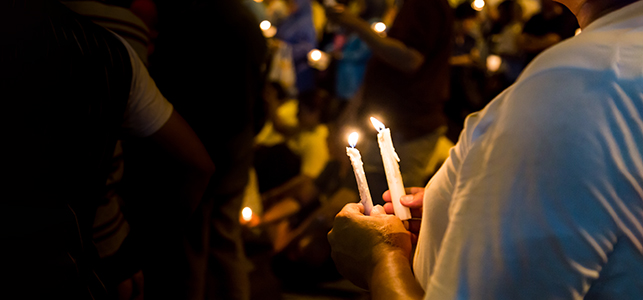 Closeup of hands holding candles