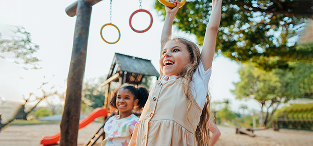 Two girls smiling while playing on the playground