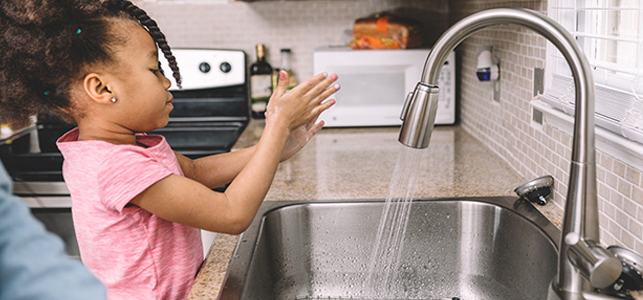 Child washing hands to prevent covid