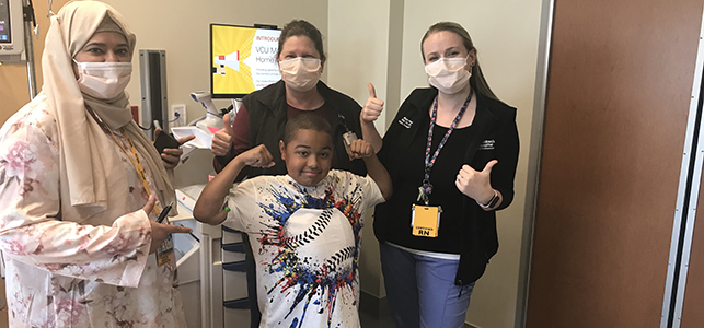 CHoR patient Damarius flexing with his muscular dystrophy research team
