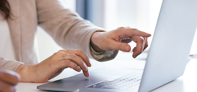 Woman's hands pointing to screen on laptop