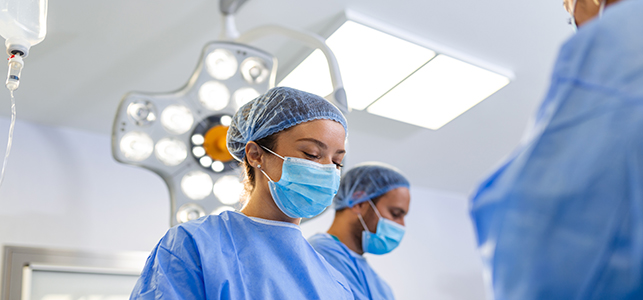 Health care providers in scrubs and masks in the OR