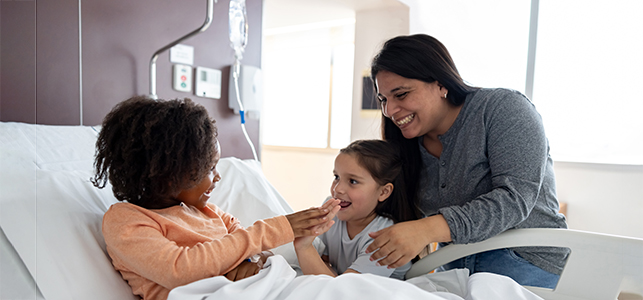 Mom and child visit friend in hospital with IV