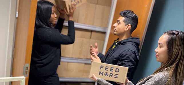 Student volunteers retrieve boxes of food to distribute to patients in need