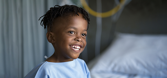 Smiling boy in hospital gown before surgery