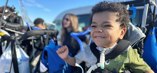 CHoR TCU patient Jariyah smiling outside on an outing with his care team
