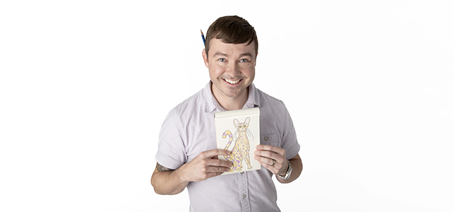 CHoR social worker Joe Roberts smiles and hold up a drawing of a cat
