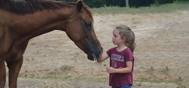 CHoR patient Maria Noles petting a horse