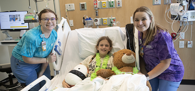 CHoR patient Cheyenne smiling with her nurses in her new Children's Tower room