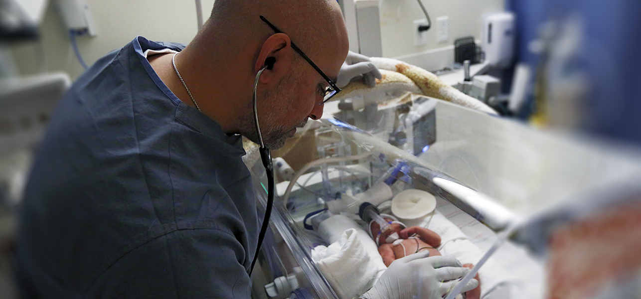 CHoR neonatologist Dr. Nayef Chahin examines an infant in an incubator
