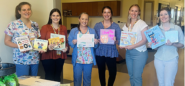 CHoR NICU team members smiling and holding books