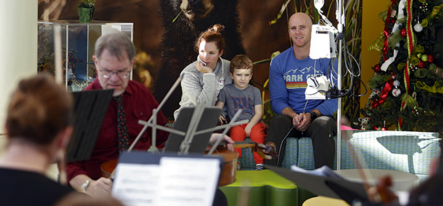 CHoR patient and his parents listen to VCU Health orchestra in the Children's Tower