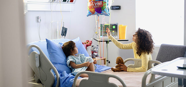 Mother and daughter looking at balloons in hospital room