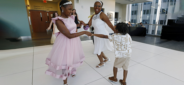 A family smiles and dances at the CHoR hematology and oncology prom