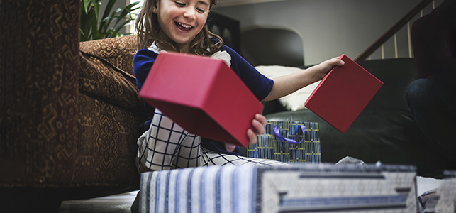 Girl smiling while opening gifts