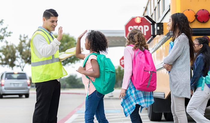 School crossing guard giving a student a high five