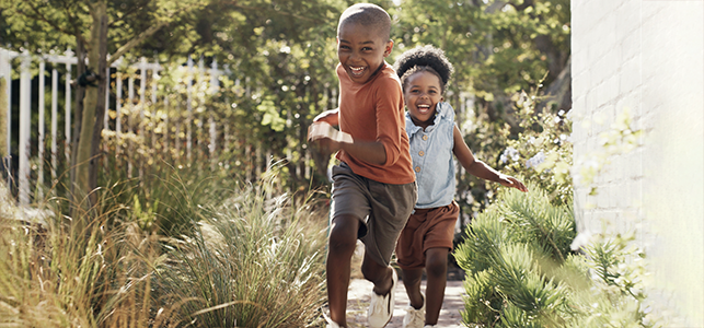 Brother and sister running outside in summer