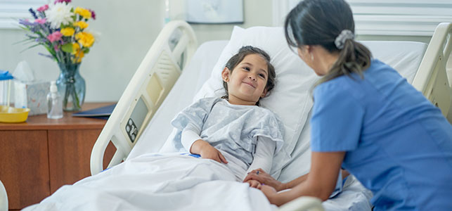 Nurse talking to pediatric patient in hospital bed