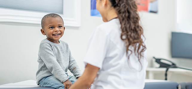 Young boy smiling at his doctor