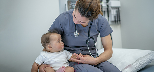 Nurse holding baby in clinic room