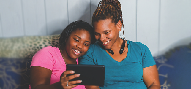 Mother and daughter looking at tablet for virtual appointment