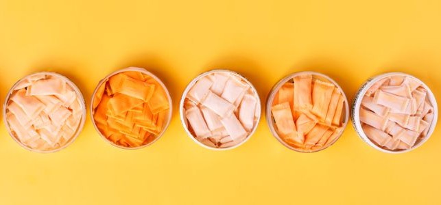 Bowls of nicotine pouches on a yellow background